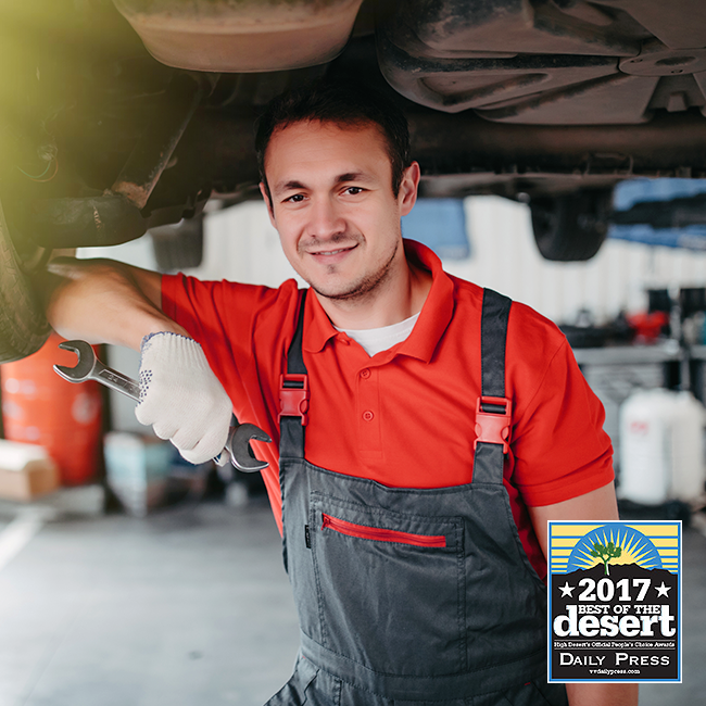 Auto mechanic with wrench smiling